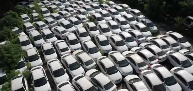 중국 전기차업계가 출혈 경쟁으로 공급과잉에 빠진 가운데 현지의 한 공터에 멀쩡한 자동차들이 방치돼 있다. 유튜브 영상 캡처