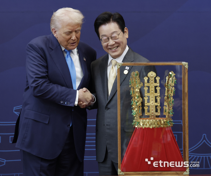이재명 대통령이 29일 경북 경주박물관에서 도널드 트럼프 미국 대통령에게 '천마총 금관 모형'을 선물한 뒤 악수하고 있다.  연합뉴스