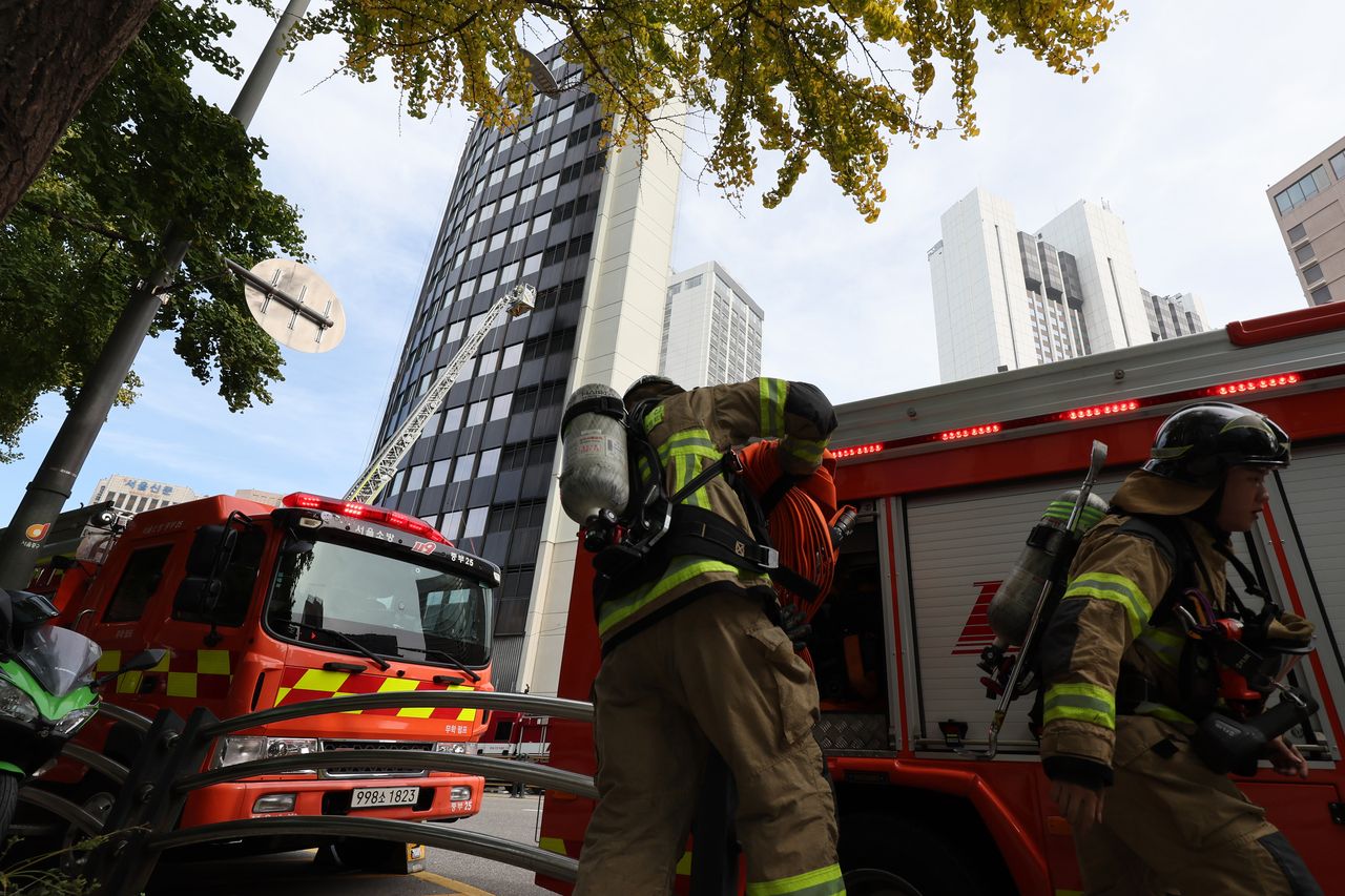 Firefighters work to extinguish a blaze at the Seoul Center Building near Seoul Plaza on Tuesday. (Yonhap)