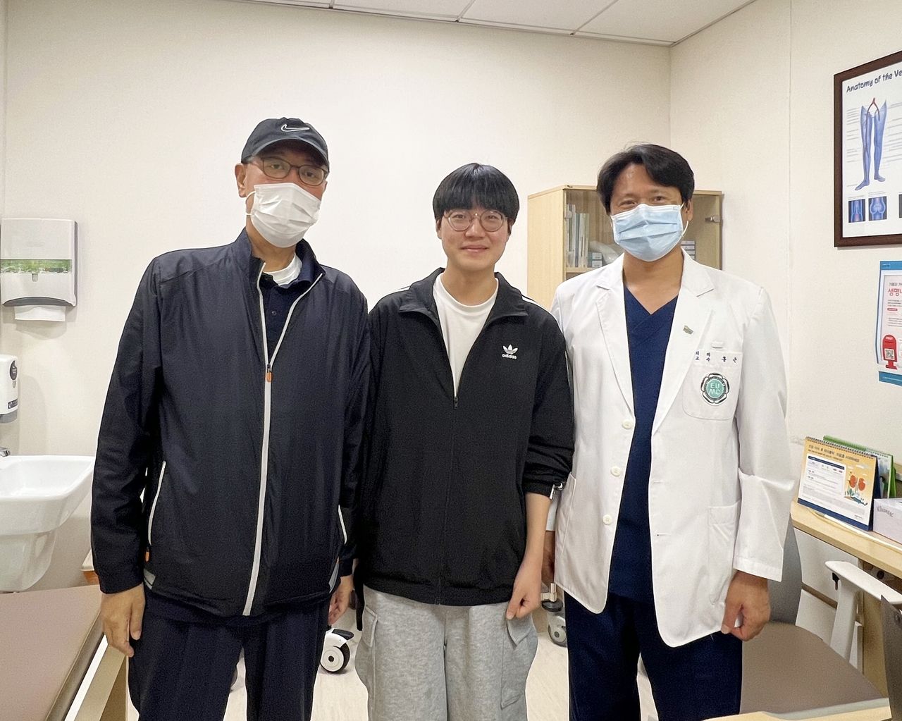 A 17-year-old high school senior, surnamed Lee (center), poses for a photo after donating a part of his liver to save his father (left) at the Ewha Womans University Medical Center. (Ewha Womans University Medical Center)
