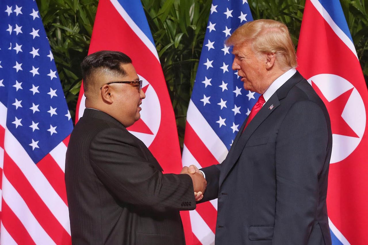 US President Donald Trump (right) and North Korean leader Kim Jong-un shake hands ahead of their historic first summit at the Capella Hotel in Singapore on June 12, 2018. (Newsis)