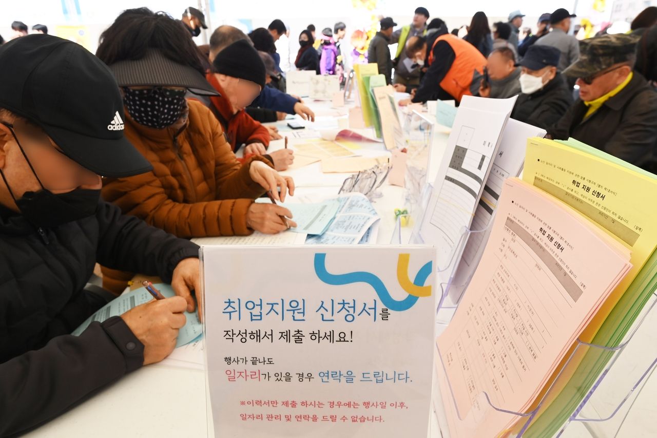 Job seekers fill out employment support forms at a senior job fair held in Hwaseong Haenggung Square in Suwon, Gyeonggi Province, on March 28. (Newsis)