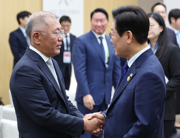  이재명 대통령이 31일 APEC 정상회의장인 경주화백컨벤션센터에서 열린 젠슨 황 엔비디아 최고경영자와의 면담에 참석한 정의선 현대차그룹 회장을 맞이하고 있다(연합뉴스)