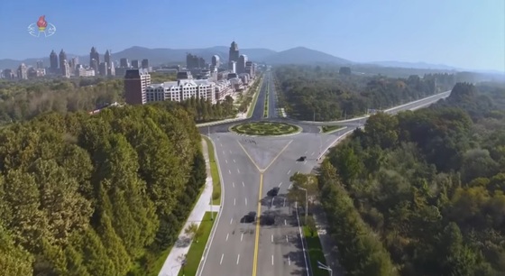  A scene broadcast by Korean Central Television on October 24 showing Kim Jong-un, General Secretary of the Workers\' Party of Korea, moving to the Combat Merit Memorial Hall. The buildings visible on the left are presumed to be residences constructed under the fourth-phase construction plan for the Hwasong District / Capture from Korean Central Television