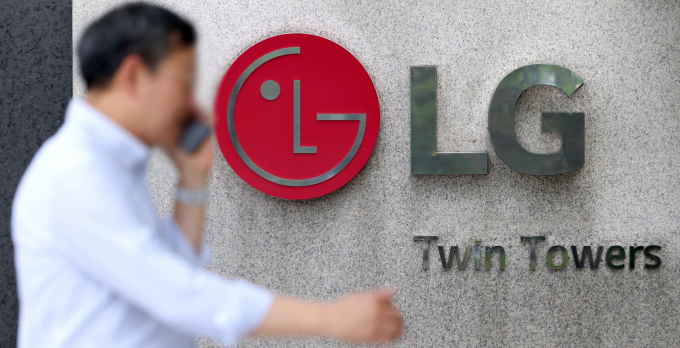 LG전자, LG디스플레이, LG에너지솔루션, LG이노텍이 독일 자동차 제조사 메르세데스-벤츠(Mercedes-Benz)와 만나 '원(One) LG' 협업 확대 방안을 논의했다. 사진은 지난 7월  한 시민이  LG전자 본사가 소재한 서울 여의도 LG트윈타워 앞을 지나고 있는 모습. /사진=뉴시스