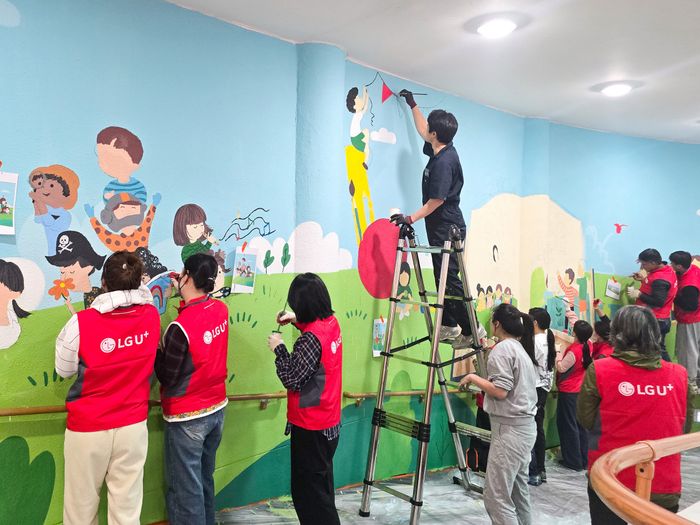 LG유플러스 임직원들이 충주성모학교 담장에 벽화를 그리고 있는 모습ⓒLG유플러스