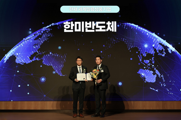 지난 18일 서울 송파구 롯데호텔월드에서 개최된 '2025 세계일류상품 인증서 수여식'에서 방효영 한미반도체 상무(오른쪽)가 최연우 산업통상부 중견기업정책관과 기념촬영을 하고 있다.