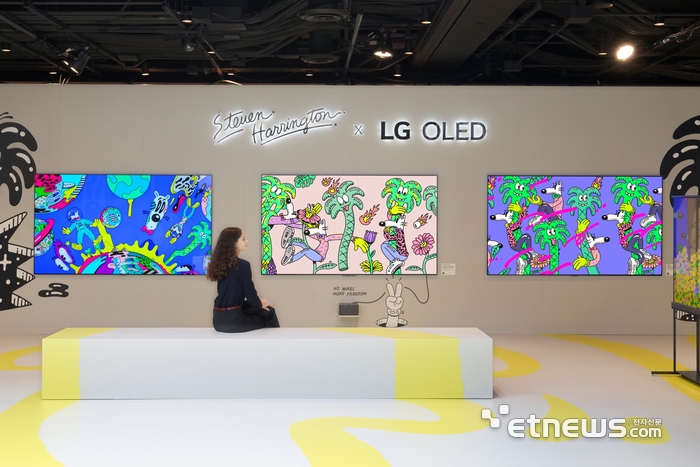 LG전자가 세계적인 아트페어 '프리즈 뉴욕'에 참가해 2025년형 LG 올레드 에보(evo) 등 TV 신제품의 압도적 화질로 표현한 팝아트를 선보인다고 7일 밝혔다. 모델이 LG 시그니처 올레드 T의 투명한 화면을 통해 재생되는 팝아트를 감상하고 있다.  LG전자 제공