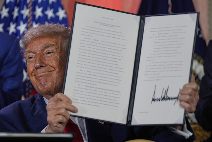 도널드 트럼프 미국 대통령이 7월 23일(현지시간) 워싱턴의 앤드류 W. 멜론 강당에서 열린 AI 정상회담에서 연설한 후 AI 인프라 허가와 관련된 행정 명령에 서명한 것을 들고 있다. 〈AP 연합뉴스〉