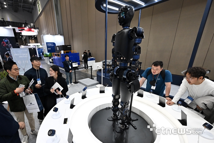 로보월드 2025가 5일 경기 고양시 킨텍스에서 열렸다. 올해로 20회를 맞은 이번 전시에는 피지컬AI에 대한 정부·민간 기업의 관심이 높아진 가운데 300여 국내 기업과 50여 개의 해외 기업이 참가해 역대 최대 규모로 열렸다. 참관객이 본시스템즈의 자체 부품 제조 기술로 개발중인 휴머노이드 로봇을 살펴보고 있다.  이동근기자 foto@etnews.com