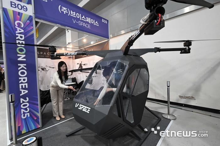 산업통상부가 주최한 '카본 코리아 2025'가 19일 서울 서초구 aT센터에서 열렸다. 브이스페이스 부스에서 관람객이 탄소섬유 소재의 미래항공모빌리티 기체를 살펴보고 있다. 김민수기자 mskim@etnews.com