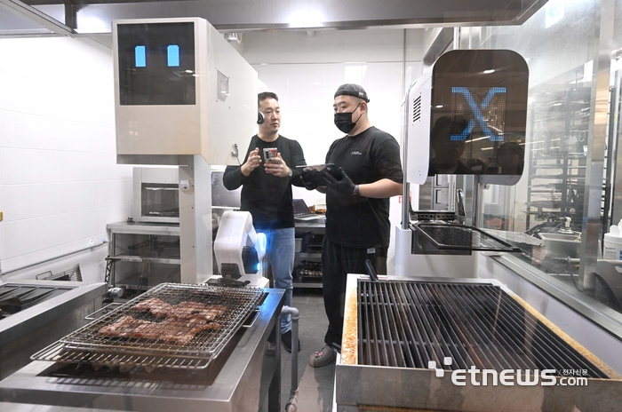 피지컬 AI가 휴머노이드 로봇부터 조리 로봇 등 다양한 분야에서 활용되고 있다. 11일 서울 강남구 비욘드허니컴에서 직원이 고기를 구워주는 AI 조리 로봇 '그릴 X(GRILL X)' 시연을 보여주고 있다. 그릴 X는 고기를 굽는 과정에서 발생하는 마이야르 반응, 육즙 손실, 지방·콜라겐 상태 등의 분자 신호를 실시간으로 감지하는 독자적인 '디지털 미각' 기술이 핵심으로 조리 경험과 관계없이 숙련된 셰프 수준의 균일하고 완벽한 고기 맛을 구현한다. 박지호기자 jihopress@etnews.com
