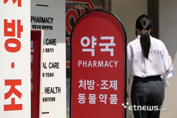 서울의 한 약국 앞을 지나는 시민들.