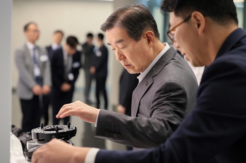 김윤 삼양홀딩스 회장이 삼양디스커버리센터에서 열린 '삼양 이노베이션 R&D 페어 2025'에서  전시 과제를 살펴봤다. 〈자료:삼양그룹〉