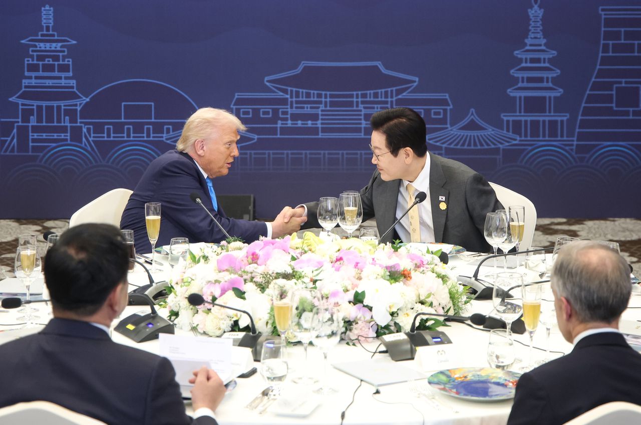 In this file photo, President Lee Jae Myung (R) shakes hands with US President Donald Trump, during a dinner banquet for state leaders participating in this year's summit of the Asia-Pacific Economic Cooperation forum at the Hilton Hotel in the southeastern city of Gyeongju on Oct. 29. (Yonhap)