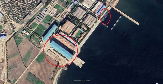 A site believed to be a nuclear submarine construction facility located on the coast of Yukdae-dong, Sinpo City, South Hamgyong Province, North Korea. The red circle on the left indicates the nuclear submarine construction facility, while the red circle on the right shows the Kim Gun-ok Hero Submarine, a nuclear missile-firing submarine built by North Korea in 2023, docked inside / Capture from Google Earth