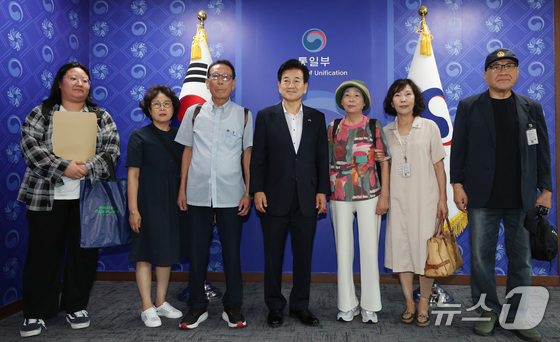 On August 8, 2025, Unification Minister Chung Dong-young poses for a commemorative photo prior to meeting with Choi Sung-ryong, Chairman of the Association of Families of Victims Abducted to North Korea Before and After the War, and its board members at the Government Complex Seoul in Jongno-gu, Seoul / News1