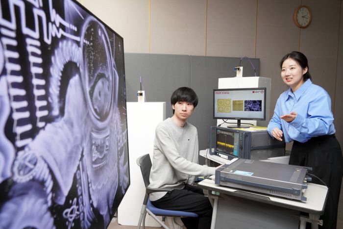 연구원들이 액자 형태의 분산형 RIS에 전파를 발사하고 통신품질을 측정하는 모습.ⓒLG유플러스