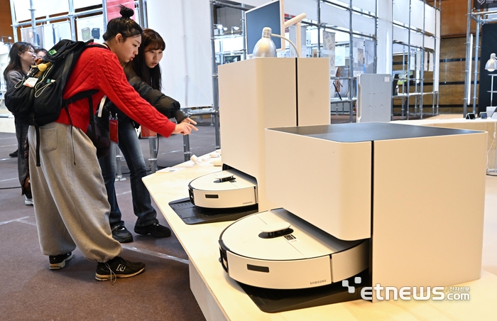 13일 서울 강남구 코엑스에서 열린 디자인코리아에서 참관객이 삼성전자의 AI물걸레 로봇청소기 '비스포크AI 스팀90 시리즈'를 살펴보고 있다.  이동근기자 foto@etnews.com