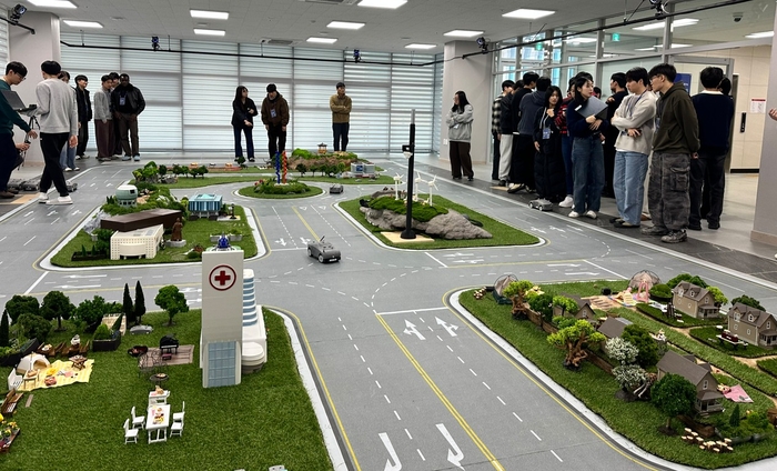 '2025 KAIST 모빌리티 챌린지 경진대회' 예선을 통과한 대학생 참가팀들이 본선 대회가 치러질 KAIST 모빌리티연구소 내 '미니어처 도시 경기장'을 둘러보며 자율 주행 기술 전략을 짜고 있다.
