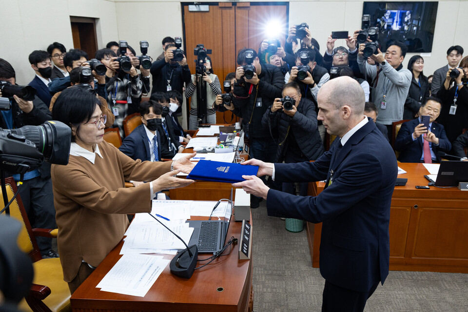 해롤드 로저스 쿠팡 임시 대표가 12월 17일 서울 여의도 국회 과학기술정보방송통신위원회에서 열린 쿠팡 개인정보 유출 사고 관련 청문회에서 증인 선서를 마친 후 최민희 과방위원장에게 선서문을 전달하고 있다. / 뉴스1
