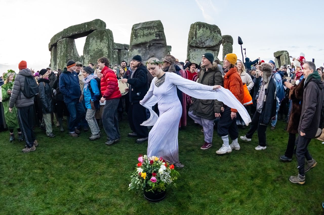 People celebrate the Winter Solstice sunrise at the Stonehenge, in Wiltshire, England, Sunday. (AP-Yonhap)