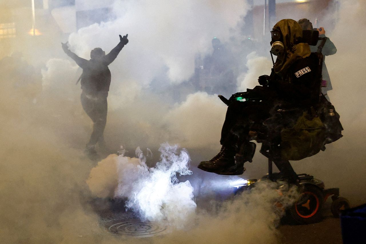 A person gestures amid tear gas as law enforcement officers advance to disperse demonstrators near US Immigration and Customs Enforcement headquarters in Portland, Oregon, in October. (Reuters-Yonhap)