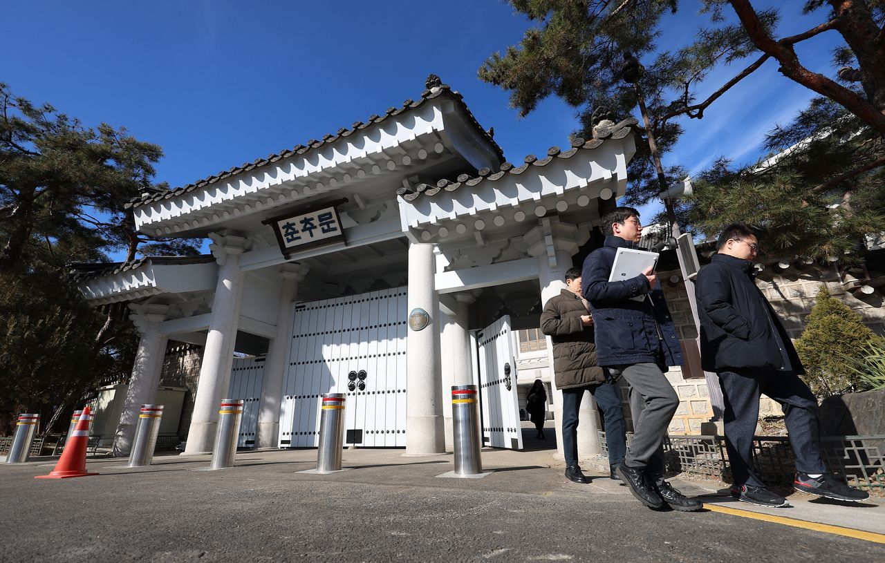 Presidential press corps members are seen Monday outside the gate for Chunchugwan, which provides a briefing room and seating for the Cheong Wa Dae press corps. (Yonhap)