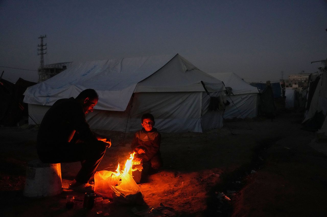 Displaced Palestinians sit by the fire in the Gaza Strip, Wednesday. (AP-Yonhap)