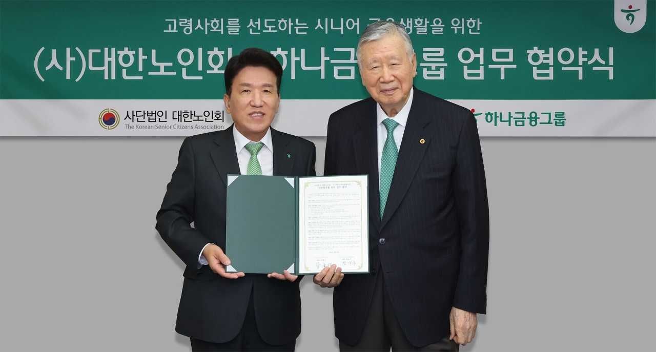 Hana Financial Group Chair Ham Young-joo (left) and Lee Joong-keun, head of the Korean Senior Citizens Association, pose for photos after signing a memorandum of understanding in central Seoul, Wednesday. (Hana Financial Group)