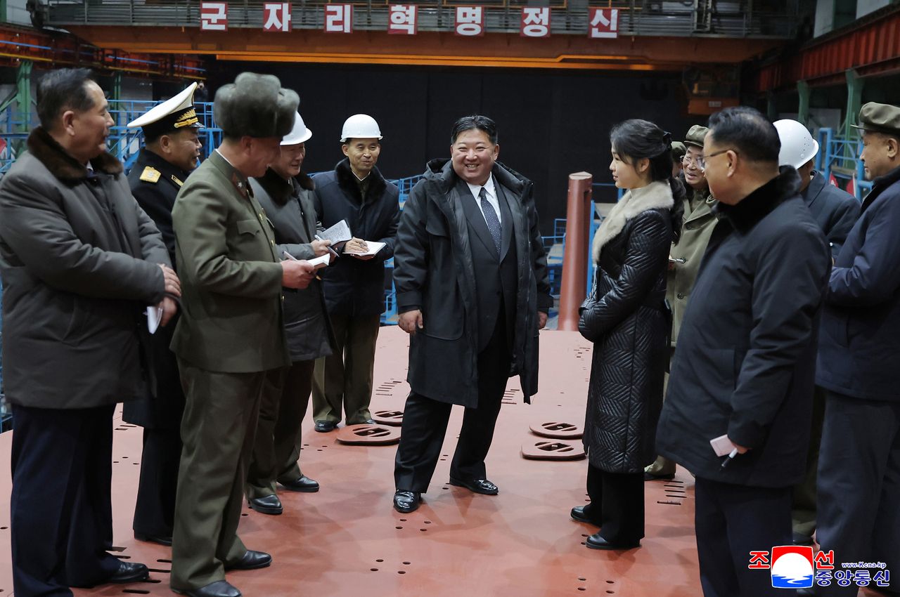 This photo, published by the Korean Central News Agency on Thursday shows North Korean leader Kim Jong-un (center) visiting the building site for an 8,700-ton nuclear-powered strategic guided missile submarine. (KCNA-Yonhap)