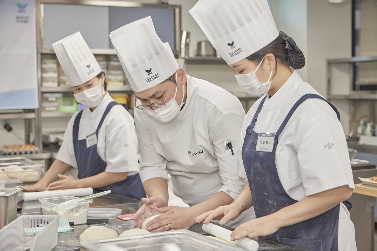 An SPC instructor works with a soldier during a baking and pastry training program at the SPC Culinary Academy in Seoul. (SPC Group)