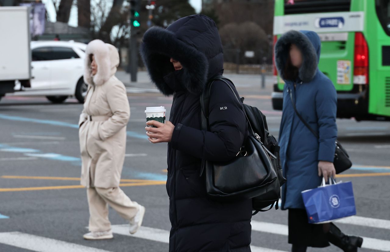 Pedestrians are seen bundled up in padded jackets in central Seoul on Friday amid the bitter cold. (Yonhap)