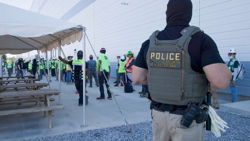 A police officer watches workers at the construction site of the HL-GA battery plant in Ellabell, Georgia, Sept 4. (US Immigration and Customs Enforcement)