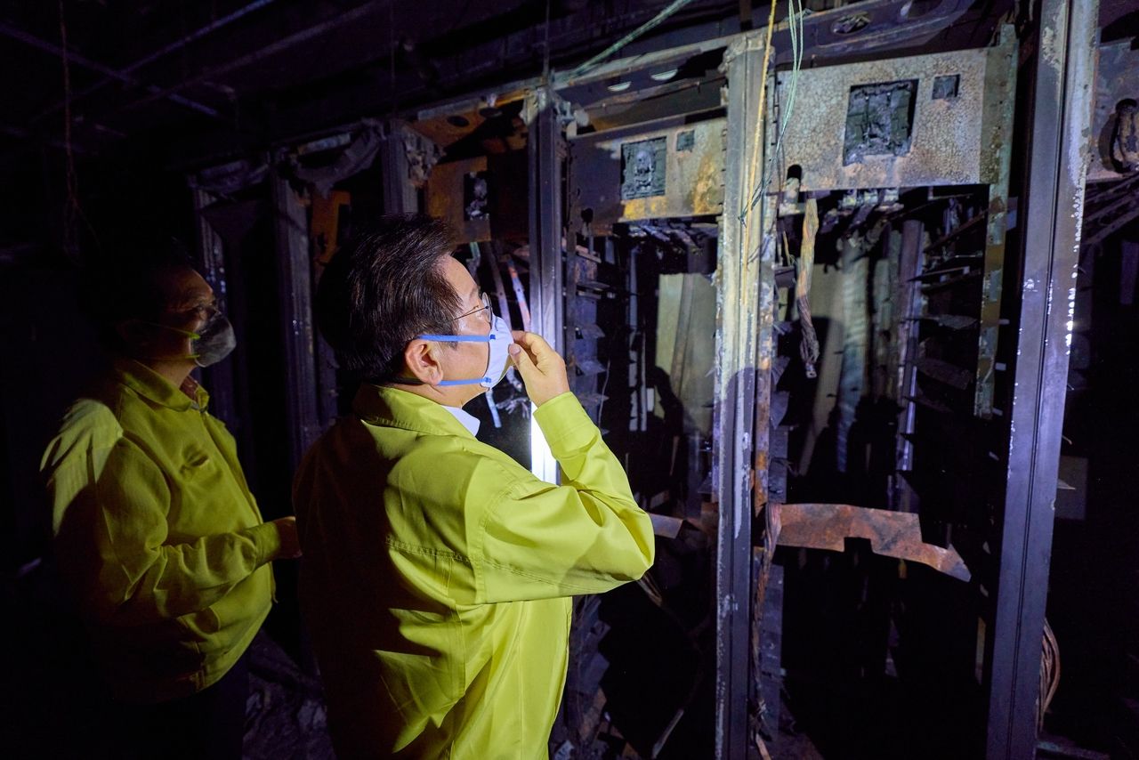This file photo provided by the presidential office shows President Lee Jae Myung (C) taking a look around the National Information Resources Service in the central city of Daejeon on Oct. 10, following a fire at the data center. (Yonhap)