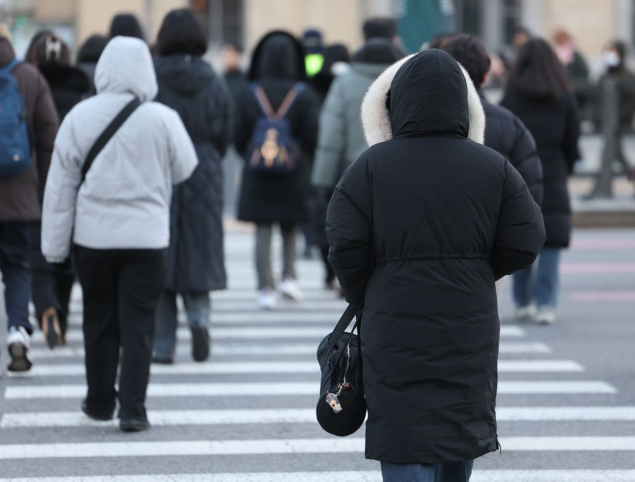 Citizens cross a road in Seoul during rush hour on Wednesday. (Yonhap)