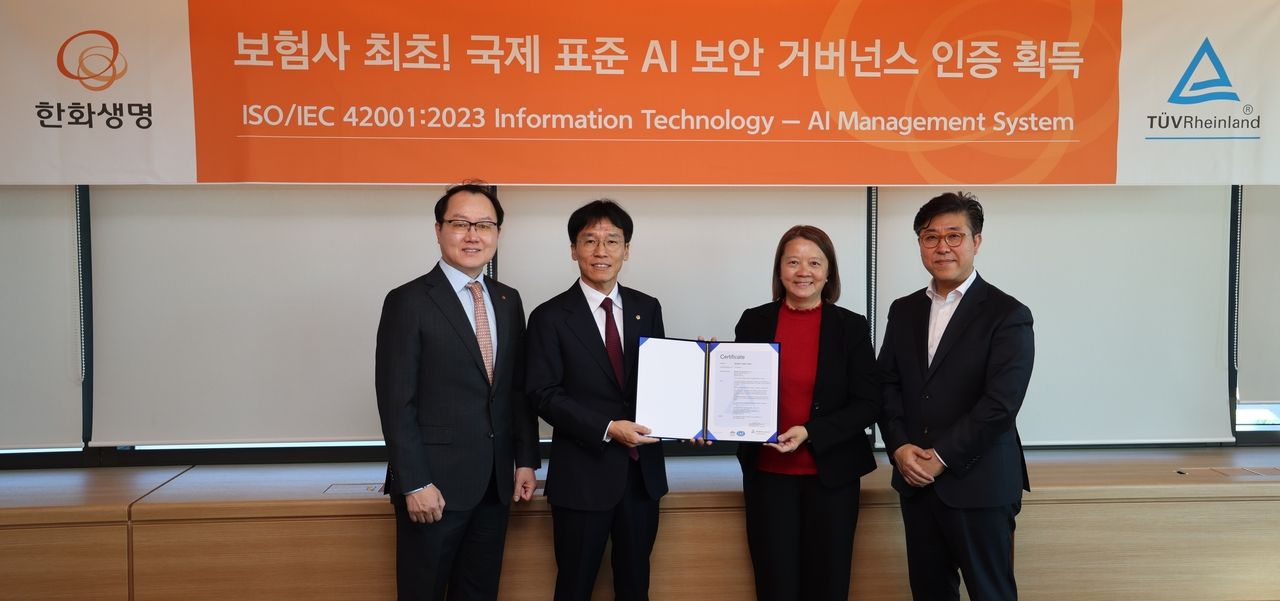 Hanwha Life Executive Vice President Lee Chang-hee (center left) and TUV Rheinland Vice President Nelly Yong (center right) pose for a photo with other officials during the ISO certification ceremony held at the Hanwha 63 Building in Yeouido, Seoul, Tuesday. (Hanwha Life)