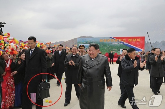  Kim Jong Un, General Secretary of the Workers\' Party of Korea, attending the completion ceremony of the Hoeryang County People\'s Power Plant on November 20, 2025. A bodyguard is seen carrying a bag / Rodong Sinmun