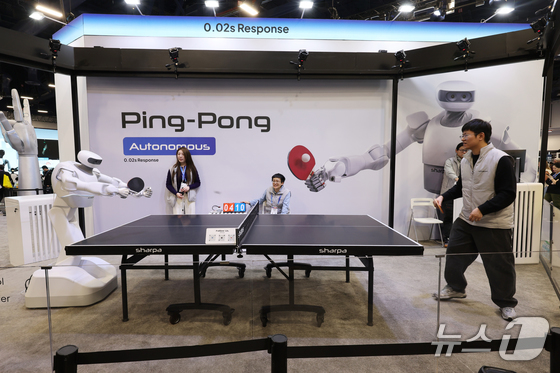  On the opening day of CES 2026, the world\'s largest IT and consumer electronics exhibition, a Sharpa robot is playing a table tennis match against a human at the Las Vegas Convention Center (LVCC) in Nevada, U.S., on Tuesday. 2026.1.7 / News1