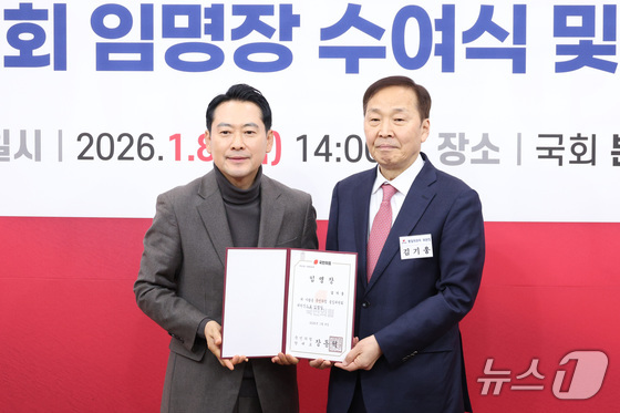 Jang Dong-hyuk, leader of the People Power Party, presents the appointment certificate to Chairman Kim Gi-woong at the appointment ceremony for the Unification Committee held at the National Assembly in Yeouido, Seoul, on Thursday. 2026.1.8 / News1