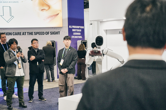  At the WIRobotics booth at CES 2026, the humanoid robot ALLEX is demonstrating the wearable walking assistance robot WIM S by holding it directly in its hand / Provided by WIRobotics