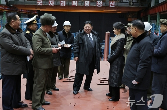 Kim Jong Un, General Secretary of North Korea\'s Workers\' Party, and his daughter Ju-ae visiting the construction site of an 8,700-ton nuclear-powered strategic guided missile submarine on December 8 last year / Rodong Sinmun