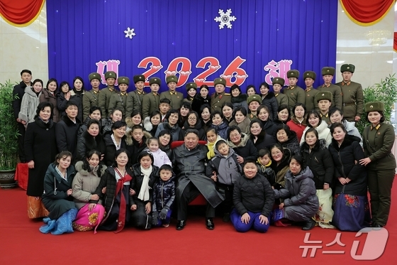 The Rodong Sinmun, the official newspaper of North Korea\'s Workers\' Party, reported on Thursday that Kim Jong Un, the party\'s general secretary, took a commemorative photo with the families of commanders from overseas operational units who attended the 2026 New Year Celebration Performance / Rodong Sinmun