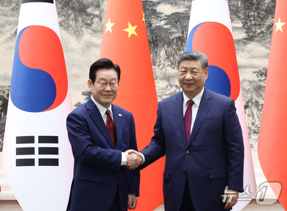  President Lee Jae Myung and Chinese President Xi Jinping shake hands at the signing ceremony for a South Korea-China MOU held at the Great Hall of the People in Beijing on Monday. 2026.1.5 / News1