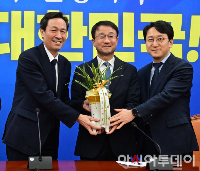 한병도 더불어민주당 신임 원내대표가 12일 국회에서 우상호 청와대 정무수석으로부터 이재명 대통령의 축하 난을 전달 받고 있다. 이병화 기자