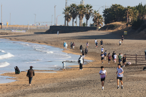 화창한 어느 겨울날 이호해수욕장에서<YONHAP NO-2725>
