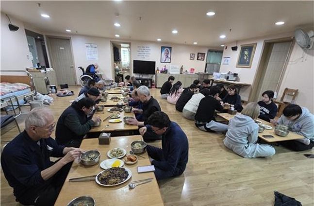 식사하고 있는 수용자, 봉사자와 관계자들 ⓒ