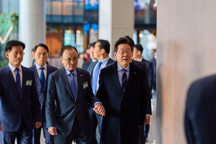 이재명 대통령이 지난해 12월 2일 경기 고양시 킨텍스에서 이해찬 민주평화통일자문회의 수석부의장과 손을 잡고 민주평통 간부 위원 임명장 수여식장으로 이동하는 모습을 SNS에 공개했다. ⓒ이재명 대통령 SNS