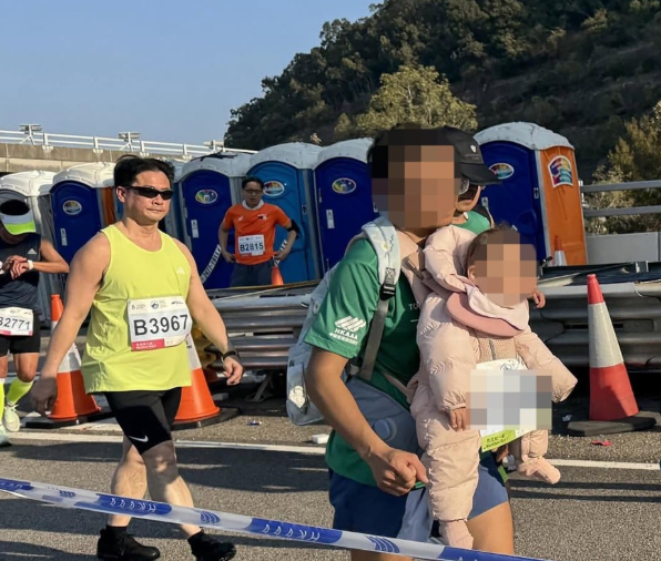 홍콩에서 열린 마라톤 대회에서 한 남성이 아기를 품에 안은 채 코스를 달려 논란이 확산되고 있다. 사진=SCMP