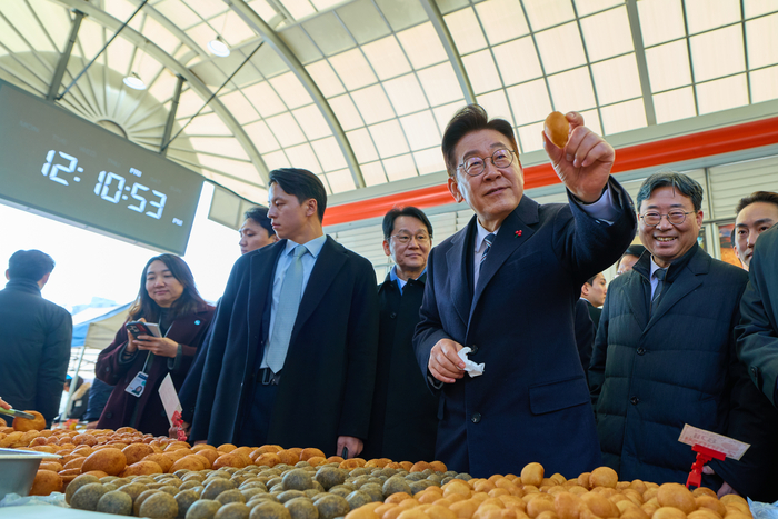 이재명 대통령이 23일 울산 울주군 온양읍 남창옹기종기시장을 방문해 음식을 구매하고 있다. 청와대 제공.